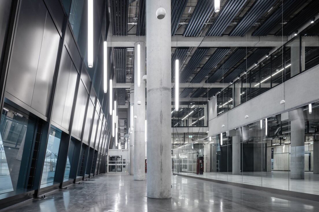 img_de_fraport_Pier_g-26 Pier G Terminal 3 Flughafen Frankfurt mit Y-Lamellen Heiz- und Kühldecke von Lindner, schräger Glasfassade und modernen Glastrennwänden im offenen Terminalbereich.