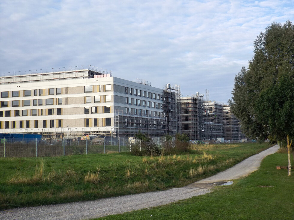 © © www.Lindner-Group.com Außenansicht des im Bau befindlichen Flugfeldklinikums Böblingen mit teilweisem Gerüst an der Fassade und Grünflächen im Vordergrund. | © © www.Lindner-Group.com