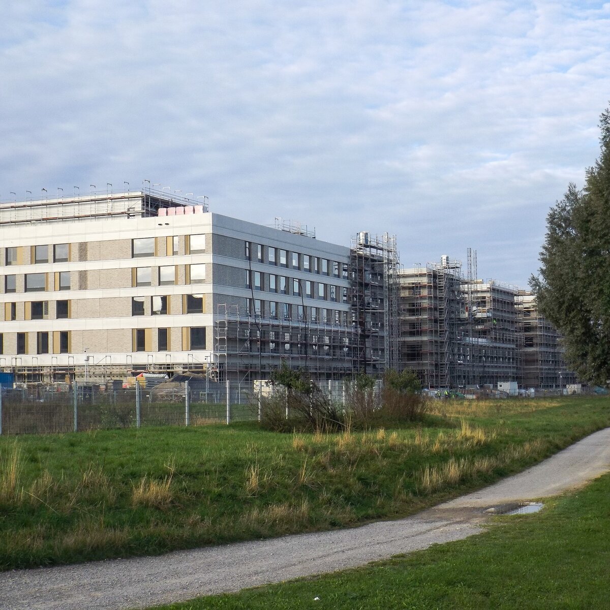 © © www.Lindner-Group.com Außenansicht des im Bau befindlichen Flugfeldklinikums Böblingen mit teilweisem Gerüst an der Fassade und Grünflächen im Vordergrund. | © © www.Lindner-Group.com