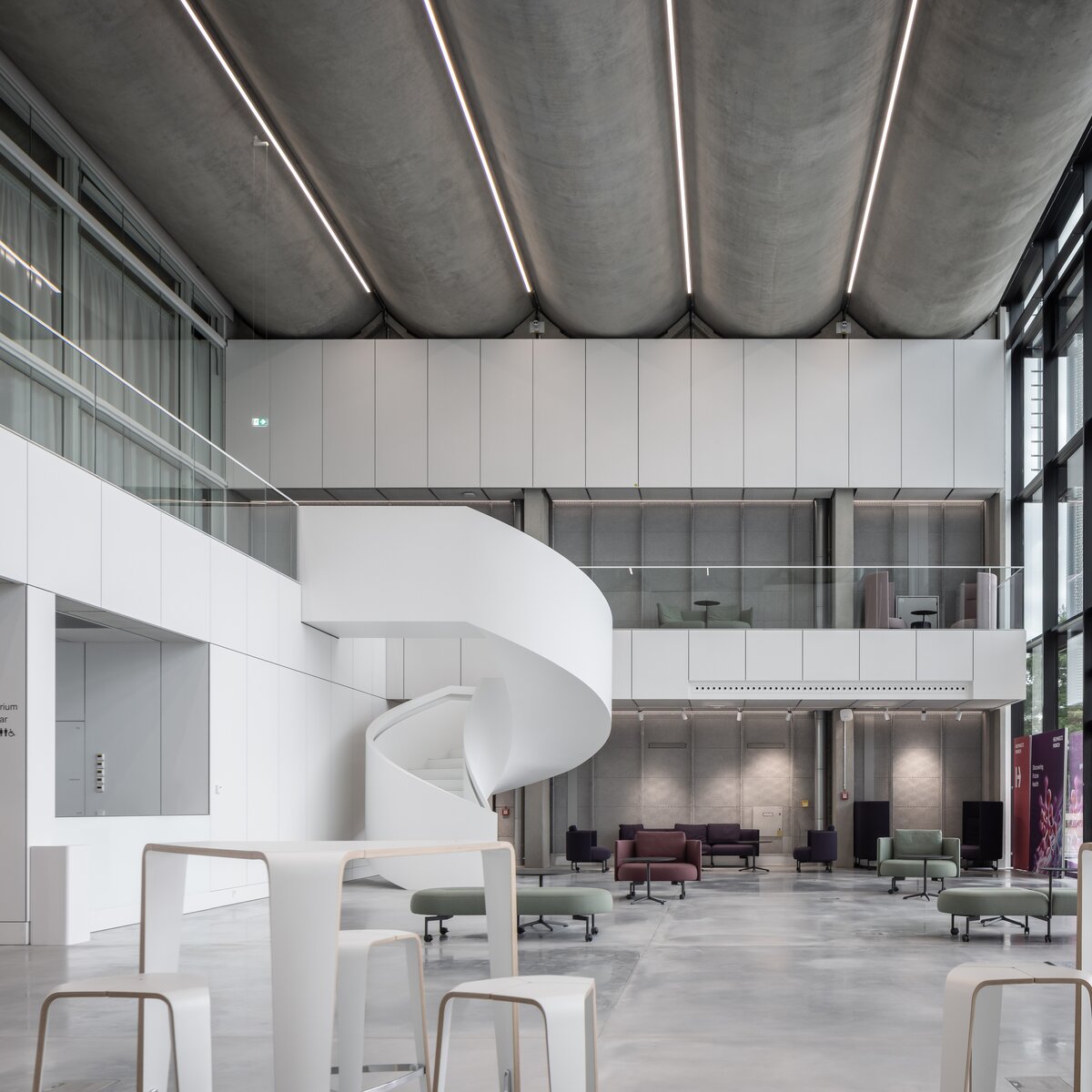 © © www.Lindner-Group.com Modernisiertes Foyer des Helmholtz Zentrums München mit geschwungener Treppe, großflächiger Verglasung und modernen Sitzbereichen. | © © www.Lindner-Group.com