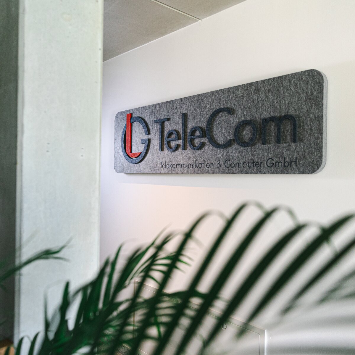 © © www.Lindner-Group.com Grauer MUTE+® board Schallabsorber mit aufgedrucktem LG TeleCom Logo an der Wand – individuelle Akustiklösung von Lindner für markenstarke Raumgestaltung. | © © www.Lindner-Group.com