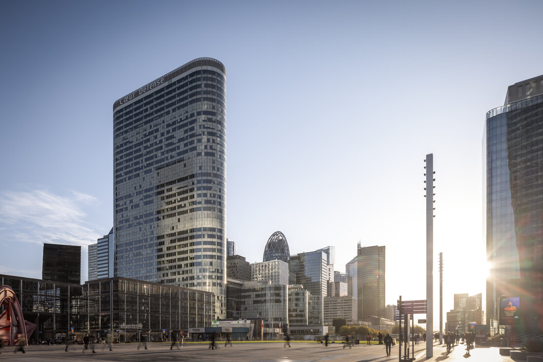 © © www.Lindner-Group.com Außenansicht des Bürokomplexes Cœur Défense in Paris mit Vorplatz, umliegenden Hochhäusern, Passanten und tief stehender Sonne | © © www.Lindner-Group.com