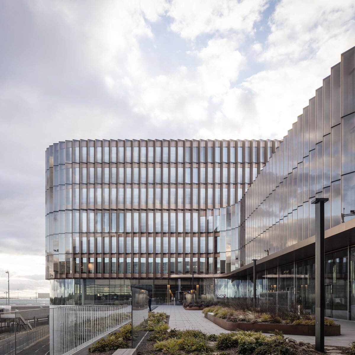 © © www.Lindner-Group.com Skypark Business Center Findel Luxemburg mit kupferfarbener Fassade, Glasfront, Lindner Innenausbauprodukten und Flughafen Luxemburg im Hintergrund | © © www.Lindner-Group.com
